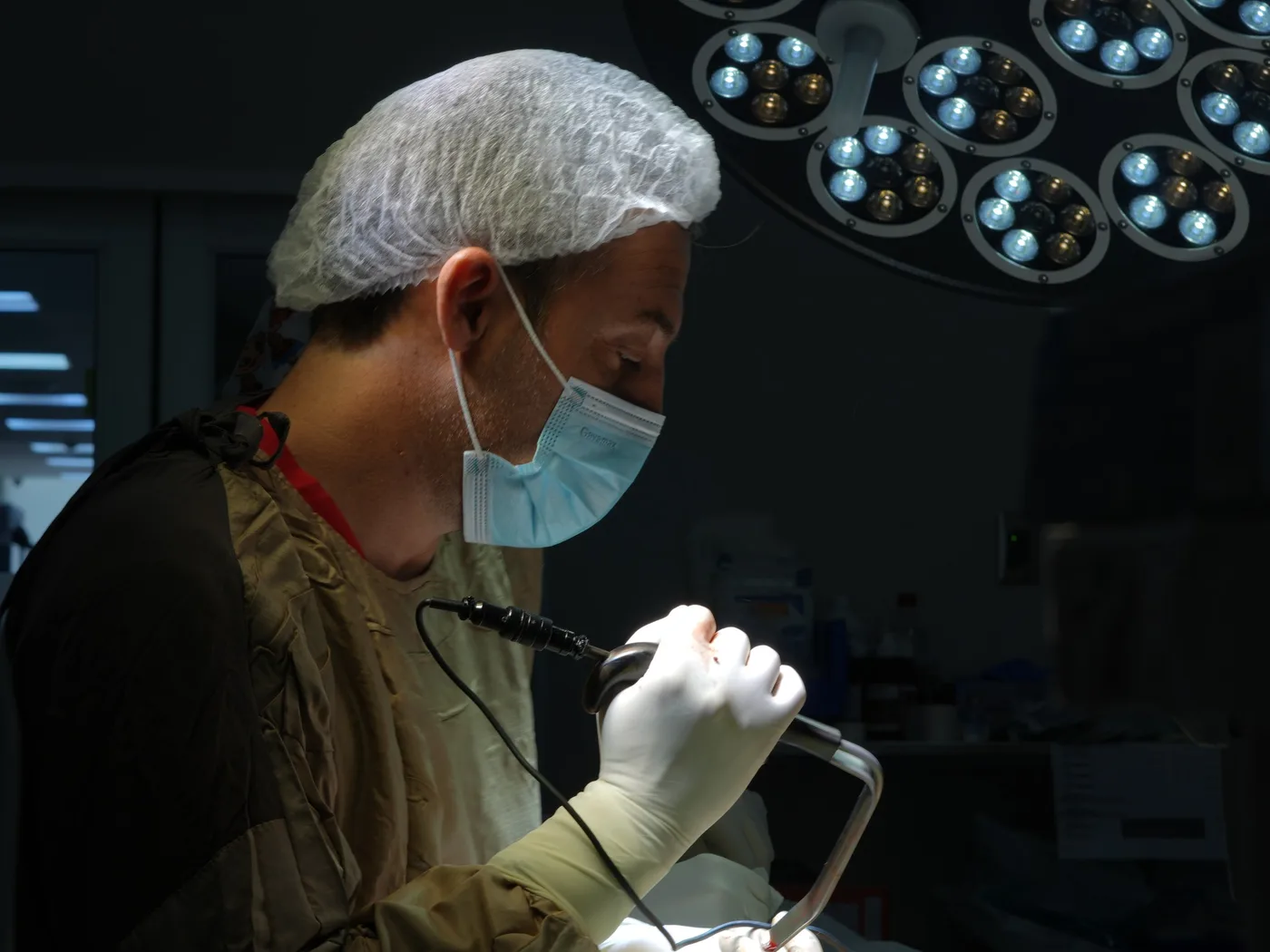 Dr. Juan Riso operando con instrumental quirúrgico